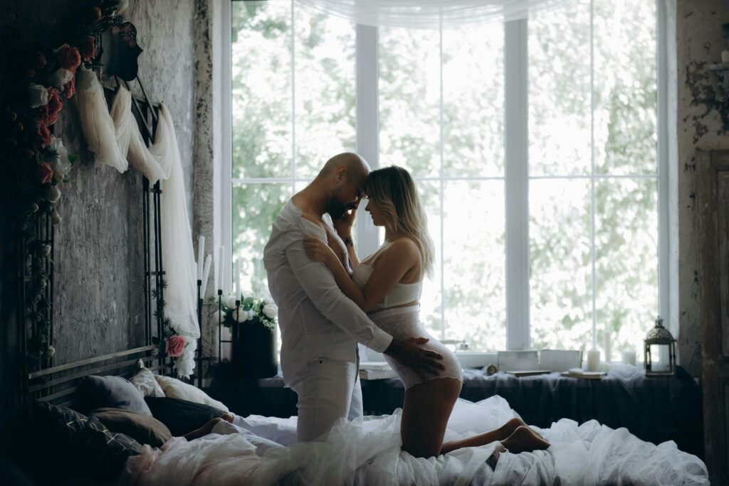 Casal demonstrando cumplicidade e felicidade, explorando a conexão emocional e intimidade com os ensinamentos do Kama Sutra Casal feliz na cama demonstrando cumplicidade, inspirados nos ensinamentos do Kama Sutra para melhorar a conexão e intimidade