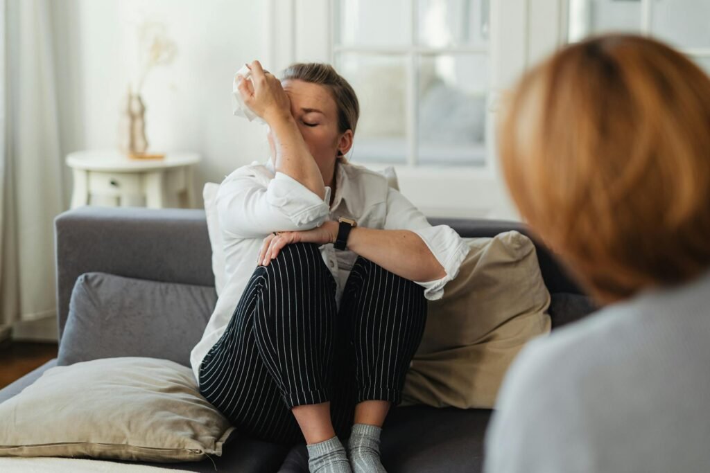 relacionamento tóxico Mulher chorando no sofá, sentindo os efeitos emocionais de um relacionamento tóxico